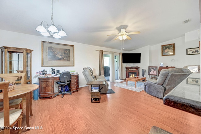 living room featuring ceiling fan with notable chandelier and light hardwood / wood-style floors