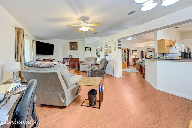 living room with ceiling fan and light hardwood / wood-style floors