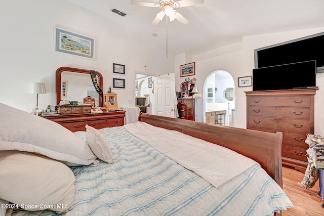 bedroom with ceiling fan, light wood-type flooring, lofted ceiling, and ensuite bathroom