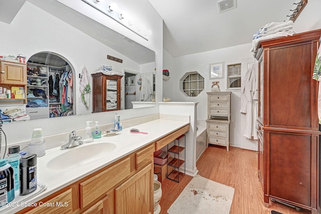 bathroom with lofted ceiling, wood-type flooring, and vanity