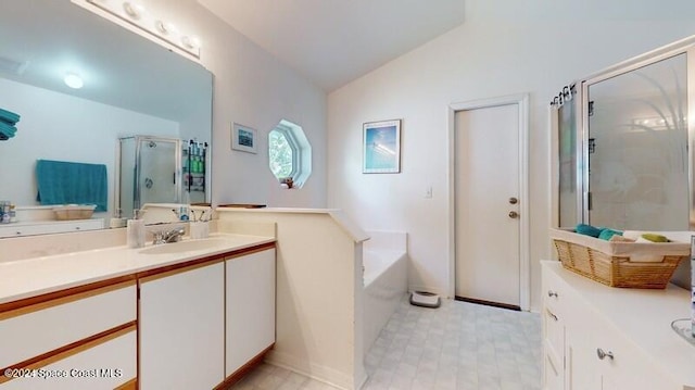 bathroom with a garden tub, a shower stall, vanity, and lofted ceiling