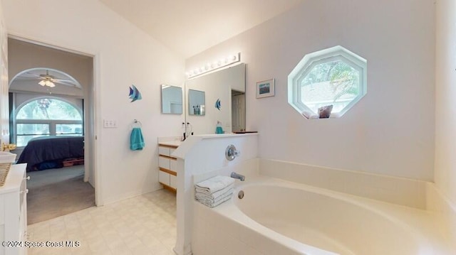 ensuite bathroom with a garden tub, vanity, vaulted ceiling, tile patterned floors, and ensuite bath