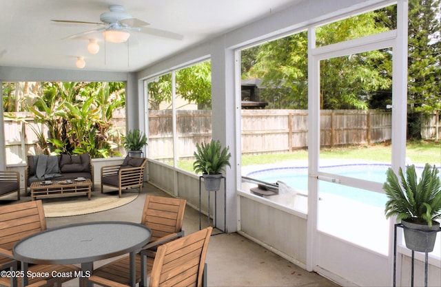 sunroom / solarium featuring a ceiling fan