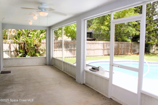 unfurnished sunroom featuring ceiling fan