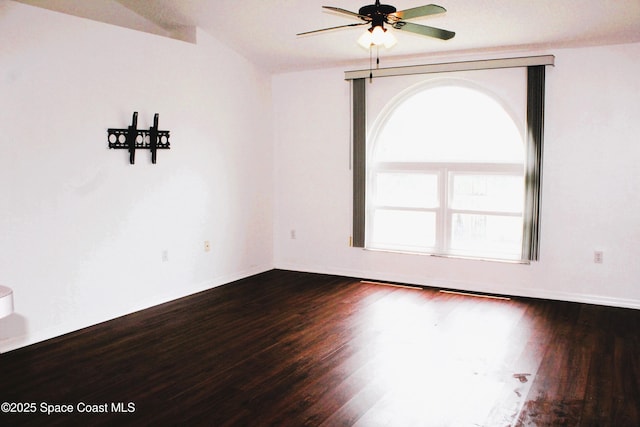 empty room with dark wood-style floors, ceiling fan, and baseboards