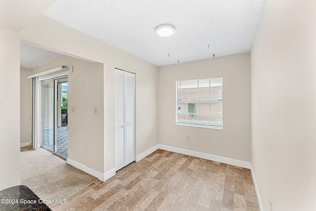 interior space with light hardwood / wood-style floors and a textured ceiling