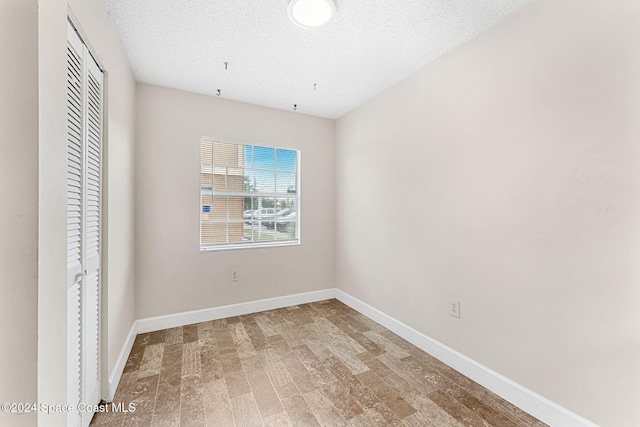 unfurnished bedroom with a closet, hardwood / wood-style floors, and a textured ceiling