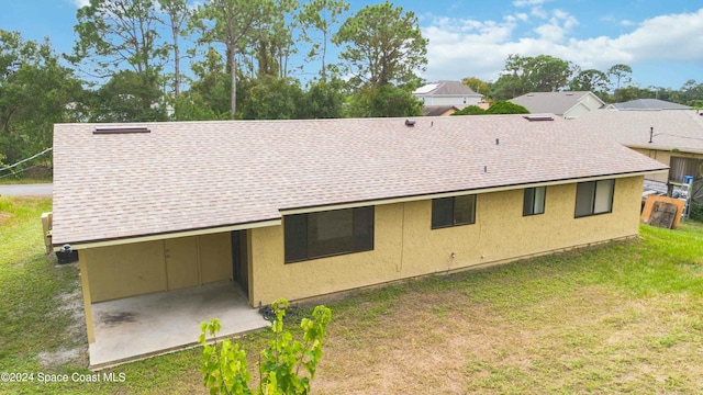 back of property with a yard and a patio