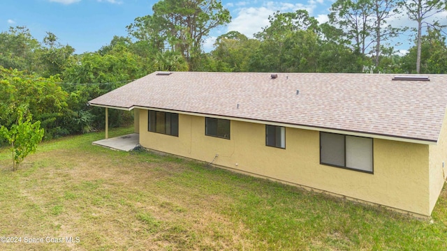 rear view of property featuring a patio area and a lawn