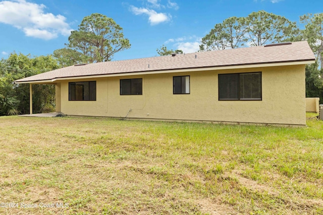 rear view of property with a yard