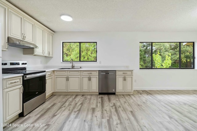 kitchen featuring cream cabinetry, plenty of natural light, sink, and appliances with stainless steel finishes