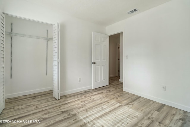 unfurnished bedroom featuring a closet and light hardwood / wood-style floors