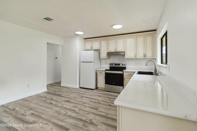 kitchen featuring white refrigerator, light wood-type flooring, stainless steel electric range oven, and sink