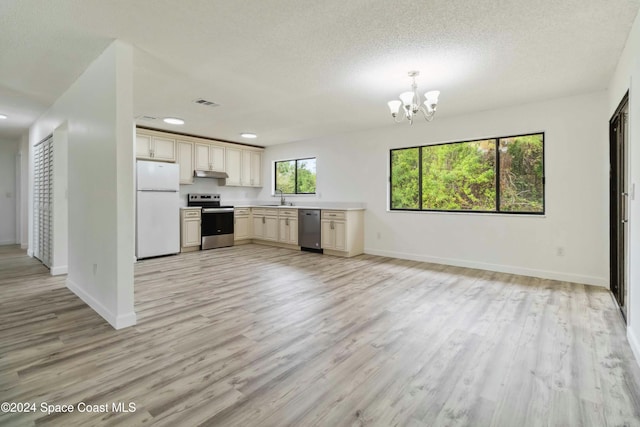 kitchen with sink, a textured ceiling, appliances with stainless steel finishes, light hardwood / wood-style floors, and a chandelier