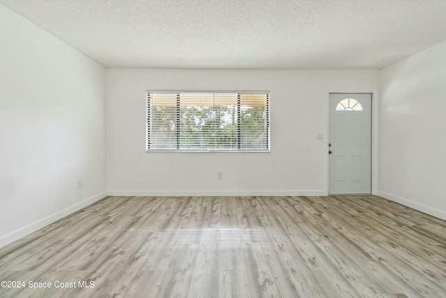 entryway with a textured ceiling and light wood-type flooring