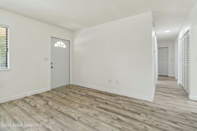 foyer with a textured ceiling and light hardwood / wood-style flooring