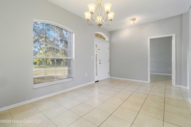 foyer entrance with light tile patterned flooring and a chandelier