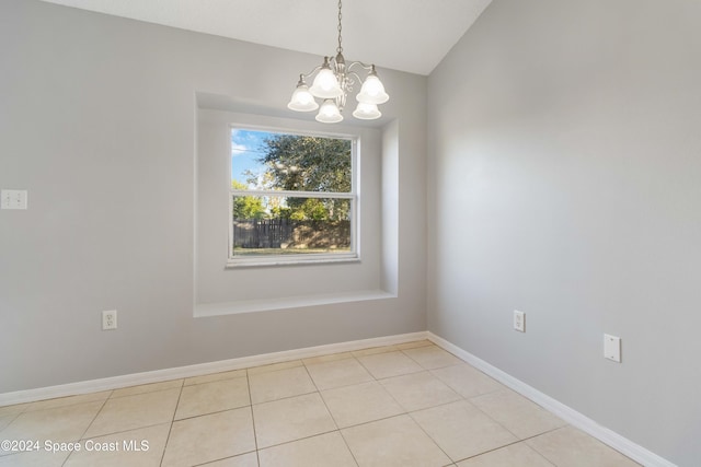 unfurnished room with a notable chandelier, light tile patterned flooring, and lofted ceiling