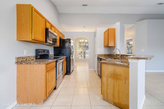 kitchen with sink, a healthy amount of sunlight, stone countertops, and appliances with stainless steel finishes