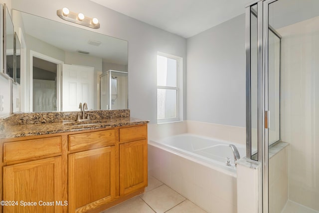 bathroom with tile patterned flooring, vanity, and independent shower and bath