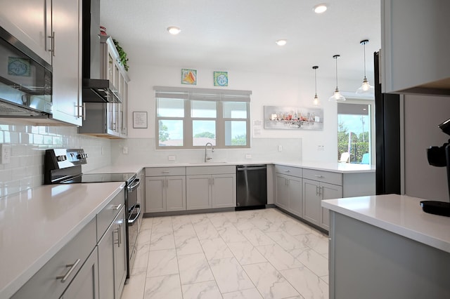 kitchen with decorative backsplash, appliances with stainless steel finishes, sink, gray cabinets, and hanging light fixtures