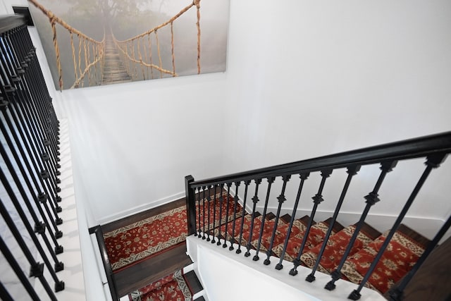 staircase with hardwood / wood-style floors