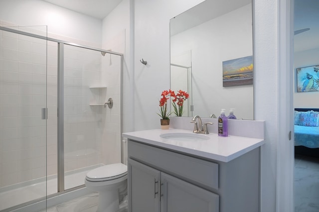 bathroom with vanity, a shower with shower door, and toilet