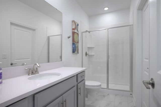 bathroom featuring vanity, a shower with shower door, and toilet