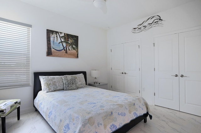 bedroom with ceiling fan and multiple closets