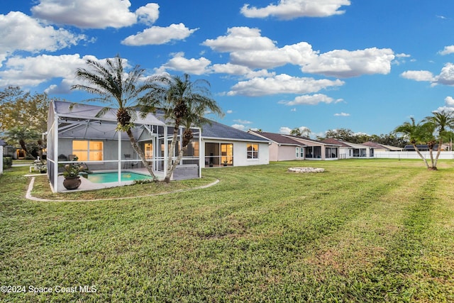 back of property featuring a lanai and a yard