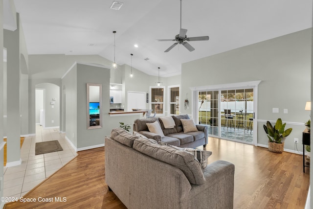 living room featuring ceiling fan, high vaulted ceiling, and light wood-type flooring