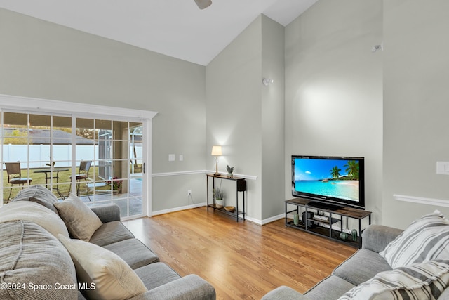 living room featuring light wood-type flooring and high vaulted ceiling