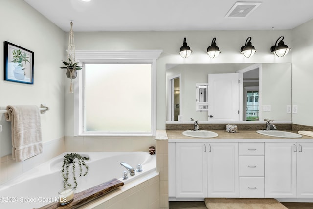 bathroom featuring vanity and a relaxing tiled tub