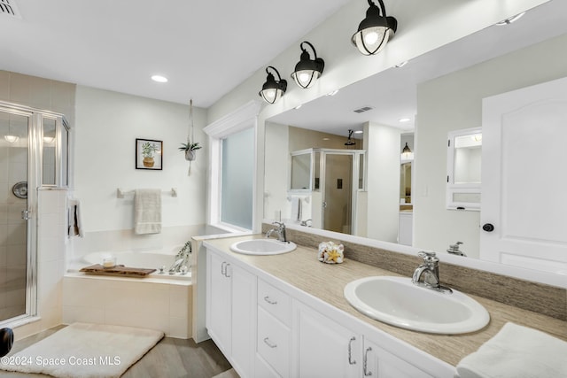 bathroom with shower with separate bathtub and vanity