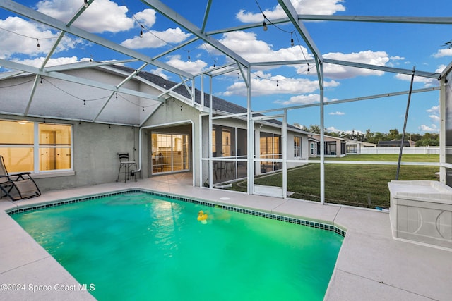 view of swimming pool featuring a lanai, a yard, and a patio