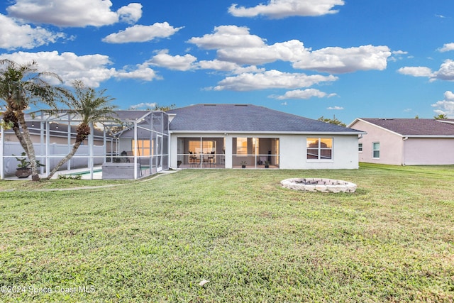 back of house featuring a lanai, a yard, an outdoor fire pit, and a swimming pool