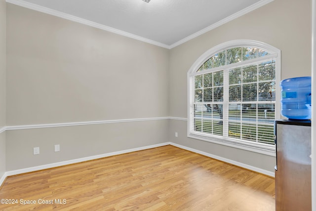 unfurnished room featuring crown molding and light wood-type flooring