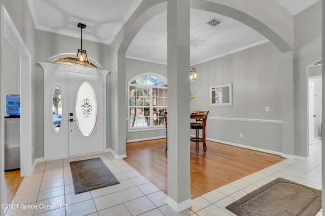 entrance foyer with crown molding and light hardwood / wood-style flooring