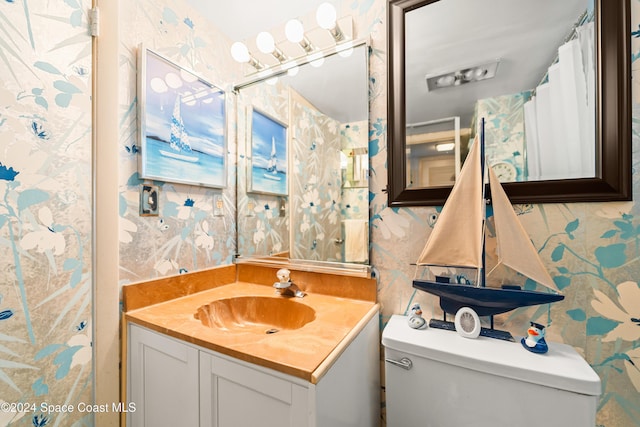 2505 S Ocean Blvd Unit 5030, West Palm Beach, FL 33407 - bathroom featuring wallpapered walls, toilet, and vanity