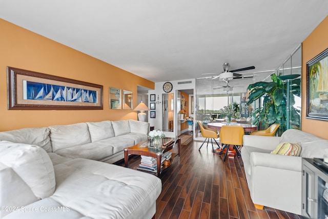 living room with ceiling fan and dark wood-type flooring