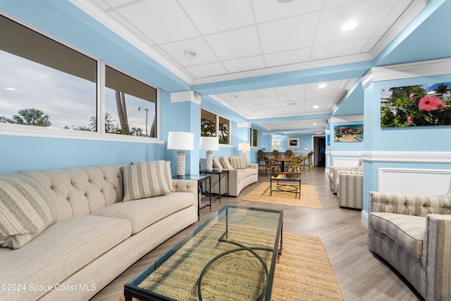 living room with hardwood / wood-style floors, a paneled ceiling, and crown molding