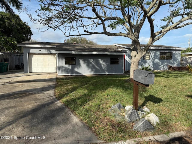 ranch-style house featuring a garage and a front lawn