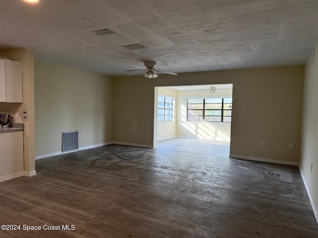 unfurnished living room featuring dark hardwood / wood-style floors and ceiling fan