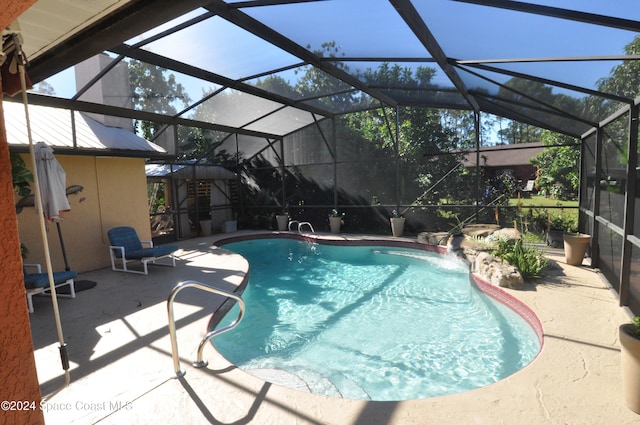 view of pool with pool water feature, a lanai, and a patio area