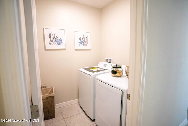 laundry room featuring washing machine and dryer and light tile patterned flooring