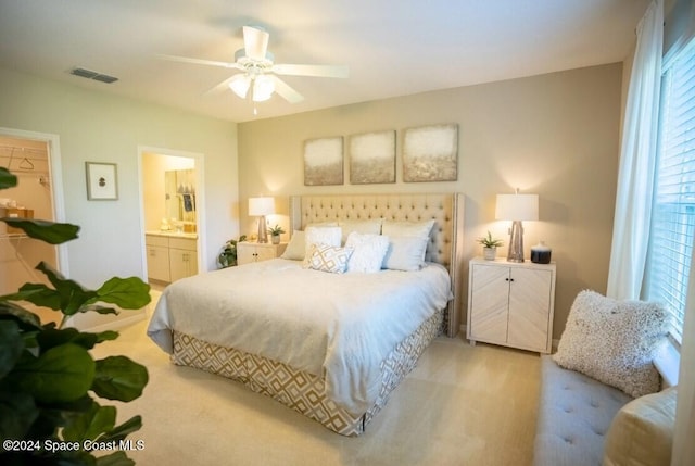 bedroom featuring connected bathroom, ceiling fan, and light colored carpet