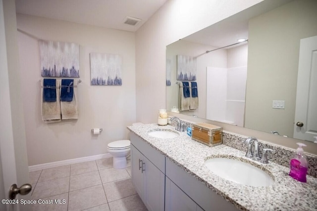 bathroom with tile patterned flooring, vanity, and toilet