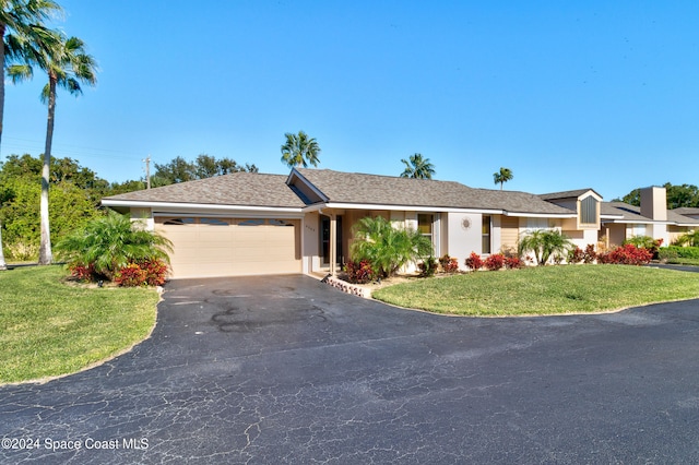 single story home featuring a front lawn and a garage