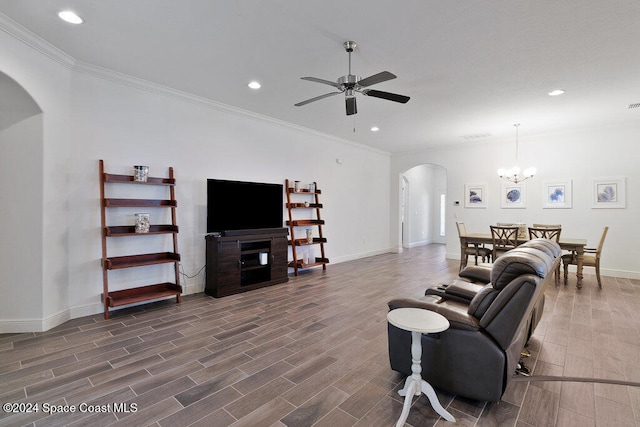 living room featuring dark wood-type flooring, ceiling fan with notable chandelier, and ornamental molding