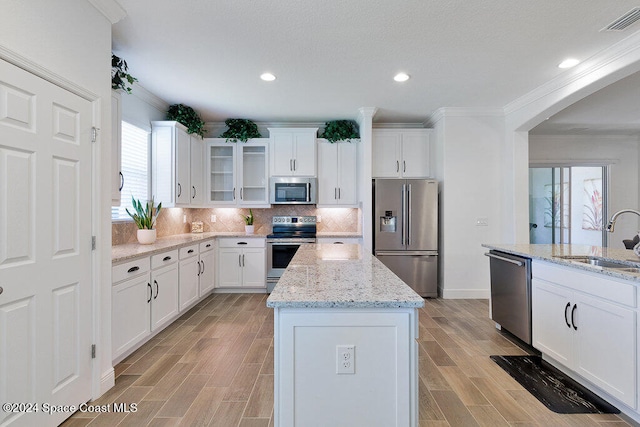 kitchen featuring a kitchen island, sink, white cabinetry, and stainless steel appliances